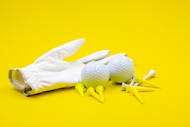 Foto la palla da golf e le t del guanto da golf sono su fondo giallo