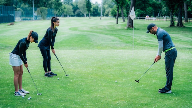 Golf leren Golfinstructeur met jonge vrouwen op een golfbaan