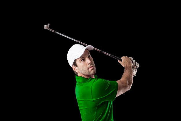 Golf Player in a green shirt taking a swing, on a black Background.