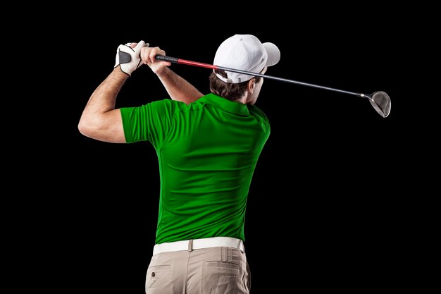 Golf Player in a green shirt taking a swing, on a black Background.