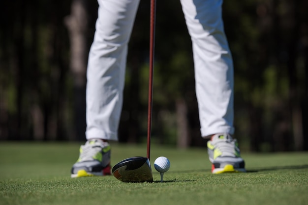 golf player hitting shot with club on course at beautiful morning