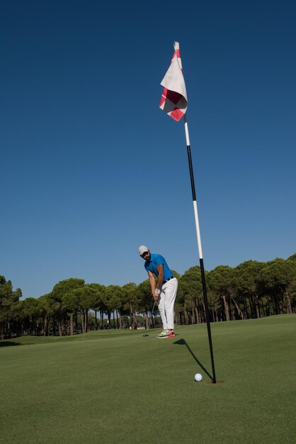 golf player hitting shot with driver on course at beautiful sunny day