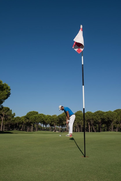 golf player hitting shot with driver on course at beautiful sunny day