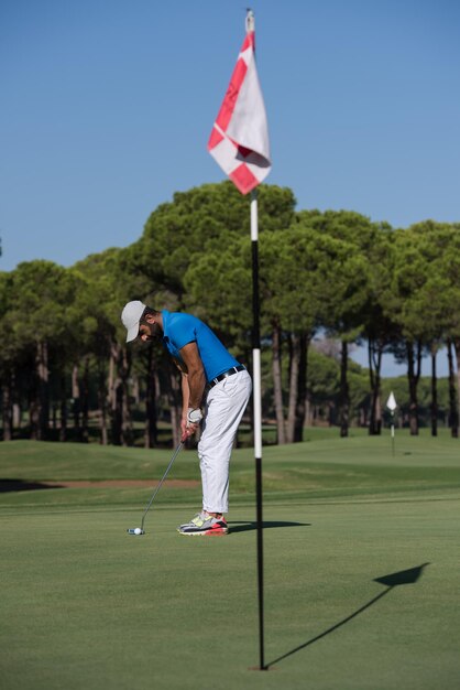 golf player hitting shot with driver on course at beautiful sunny day