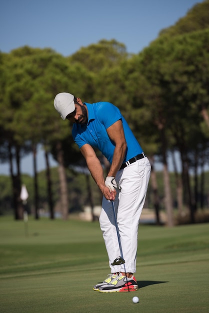 golf player hitting shot with driver on course at beautiful sunny day