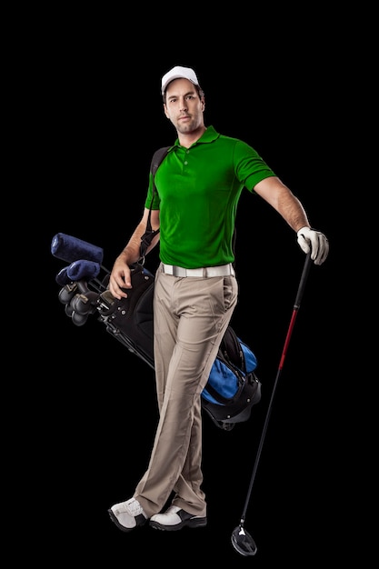 写真 黒の背景に、背中にゴルフクラブのバッグを持って立っている緑のシャツを着たゴルフプレーヤー。