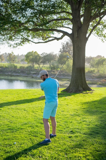 Golf player on professional golf course golfer with golf club taking a shot