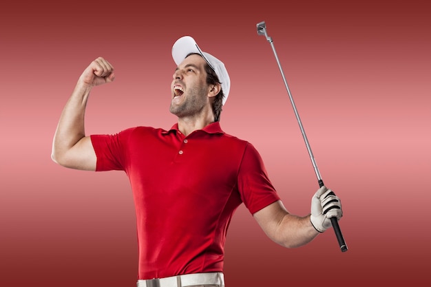 Игрок в гольф в красной рубашке празднует, на красном фоне.