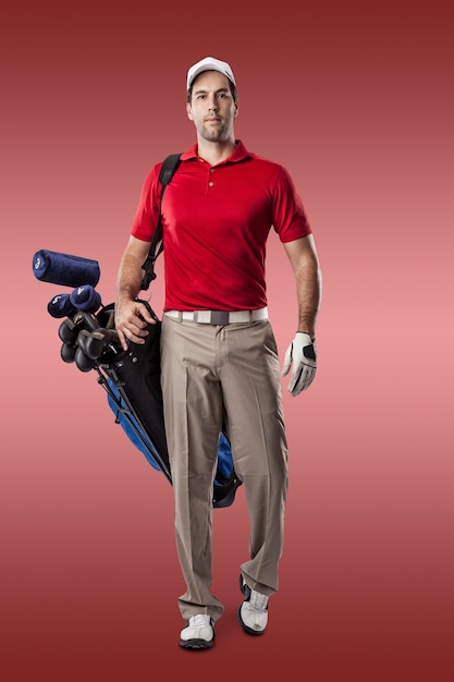 Golf Player in a red shirt walking with a bag of golf clubs on his back, on a red Background.