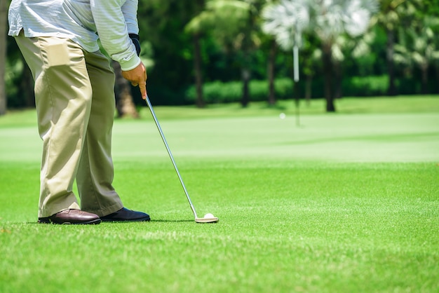 Photo golf putter putting athletes to hit a golf ball into the hole to reach the goal