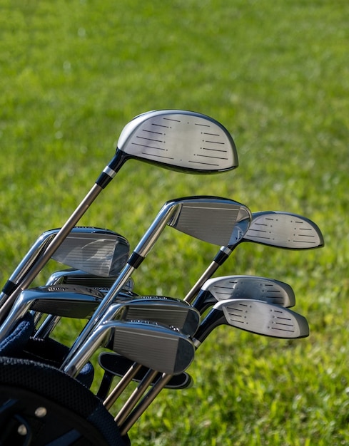 Golf sticks on green grass golf course close up view