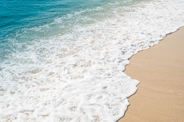 Golf van blauwe oceaan op zandstrand. textuur achtergrond.