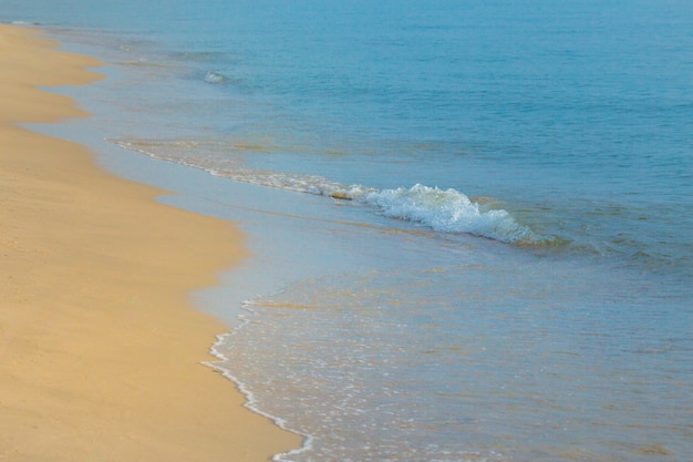 Golf van blauwe oceaan op zandstrand.