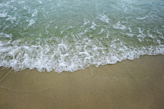 golf van groene oceaan aan zandstrand