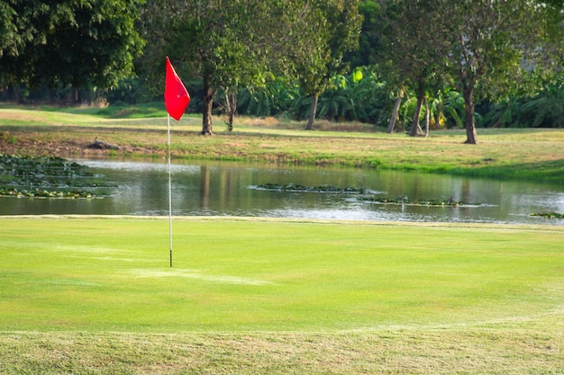 Golfbaan en vijver met rode vlag