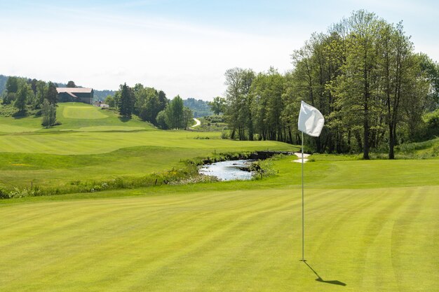 Golfbaan. Gat met een witte vlag op een zonnige dag