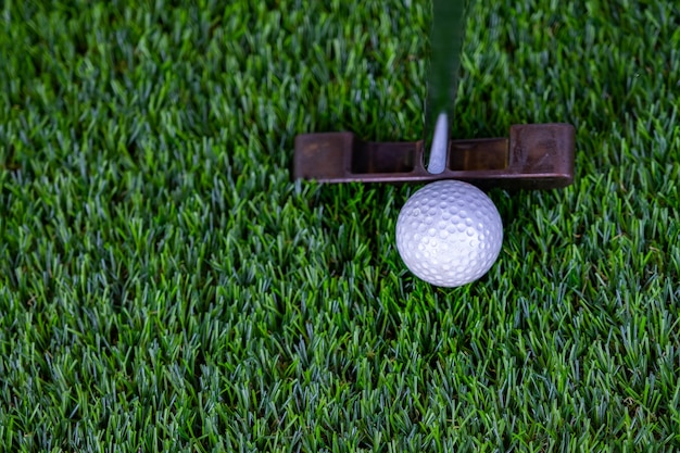 Foto golfbal met putter op groen gras