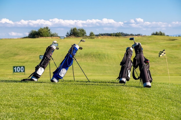 Foto golfclubs in tassen die op een zonnige dag op de golfbaan liggen