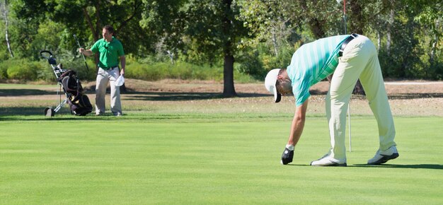 Photo golfer and caddy on putting green