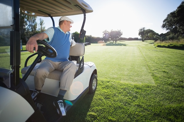 Golfer die zijn golfbuggy in omgekeerde richting drijft