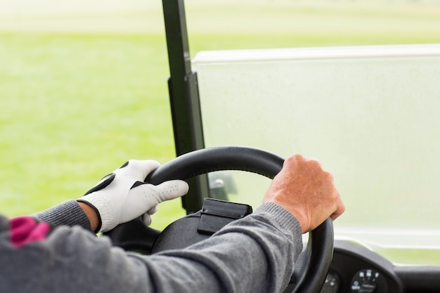 Golfer driving his golf buggy forward 