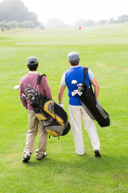 Foto amici di golfista camminando e chiacchierando