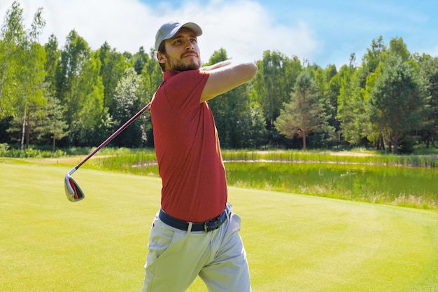 Golfer hitting golf shot with club on course while on summer vacation