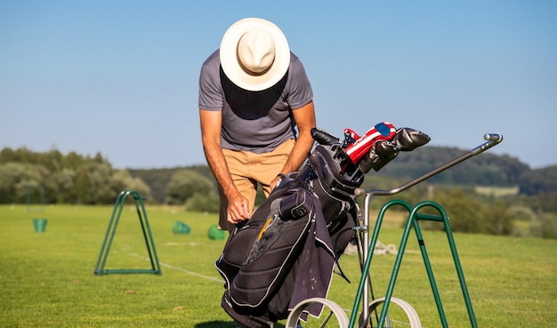 ゴルファーがゴルフ場で用具をバッグに詰める