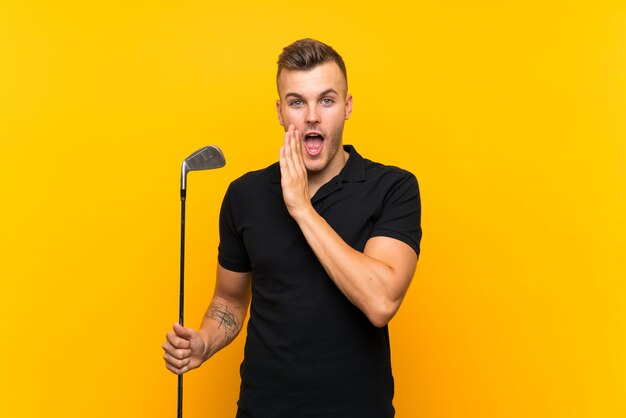 Golfer player man over isolated yellow wall whispering something