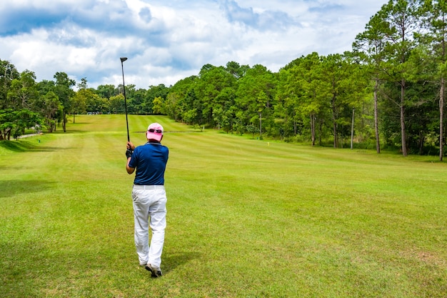 Golfer swing ball on fairway in golf course