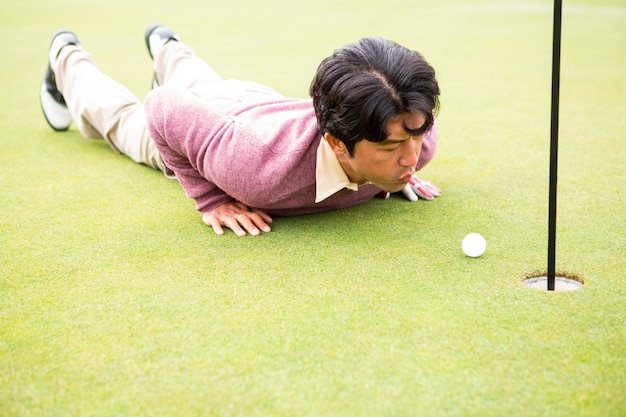 Golfer trying to flick ball into hole