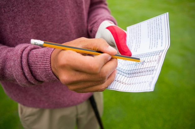 Golfer writing his points in paper