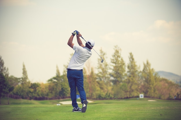 Golfers hit sweeping golf course in the summer vintage color