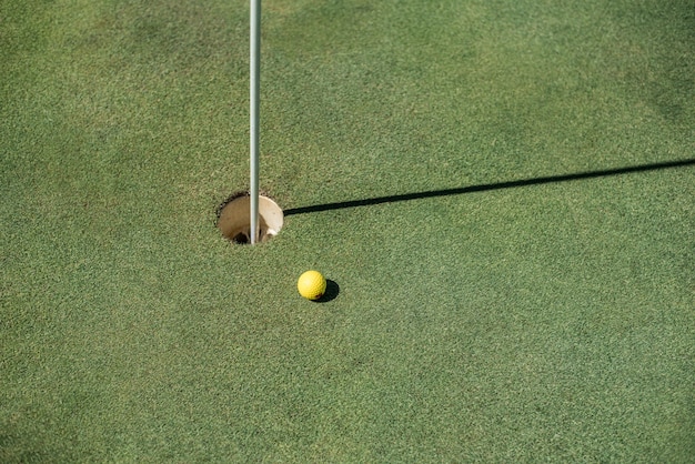 Foto golfgebied met gele bal dichtbij het gat