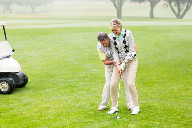 Golfing couple putting ball together