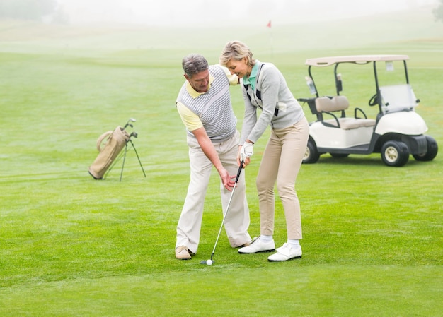 Golfing couple putting ball together