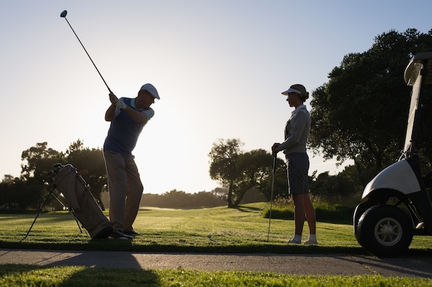 Golfing couple teeing off for the day