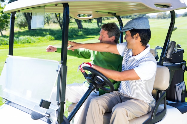 Golfing friends driving in their golf buggy