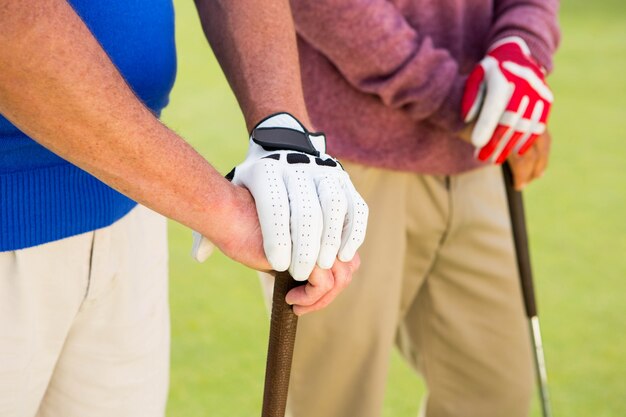 Photo golfing friends standing and holding clubs