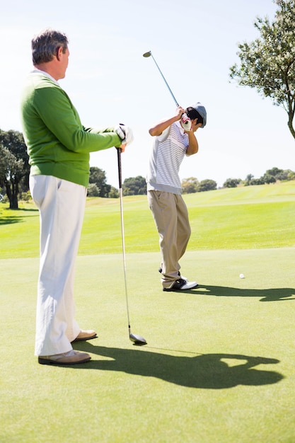 Golfing friends teeing off 