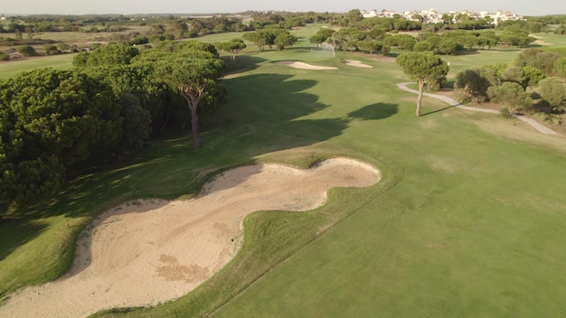 Foto golfkamp top uitzicht op greens fairway weg meren en zand bunkers op de golfbaan bij zonsondergang