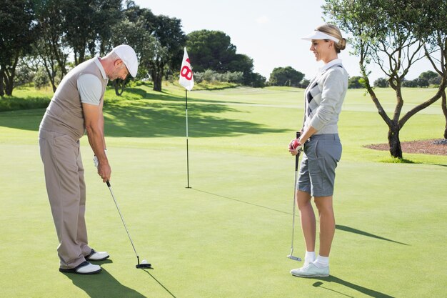 Golfkoppel op het putting green bij het achttiende hole