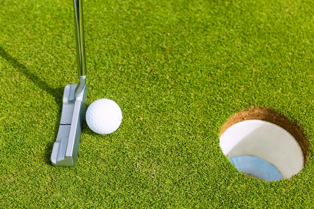 Golfspeler die bal in gat zet