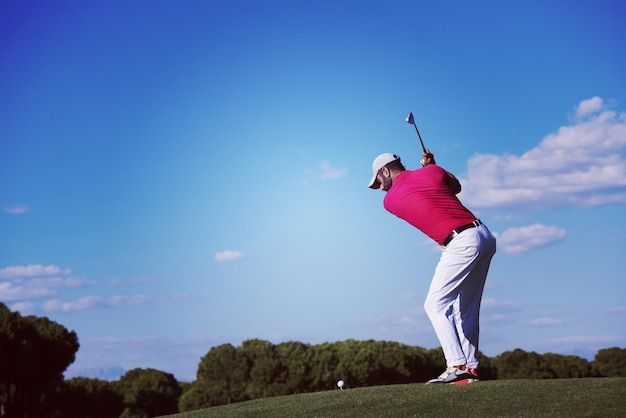 Foto golfspeler raakt schot met chauffeur op koers op mooie zonnige dag