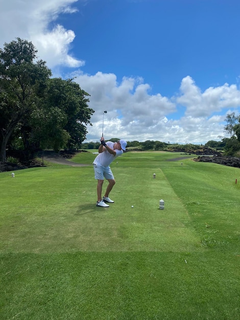 Golfspeler raakt veld met club tijdens zomervakantie