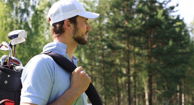 Golfspeler wandelen en draagtas op cursus tijdens golfen in de zomer.