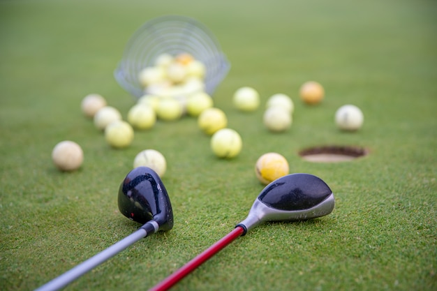 golfuitrusting op groene golfbaan, ballen en stokken klaar om te spelen