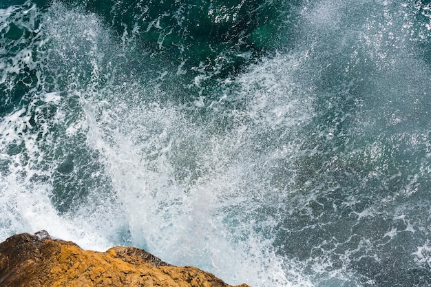 Golven die breken op rotsachtige kust. Uitzicht van boven.