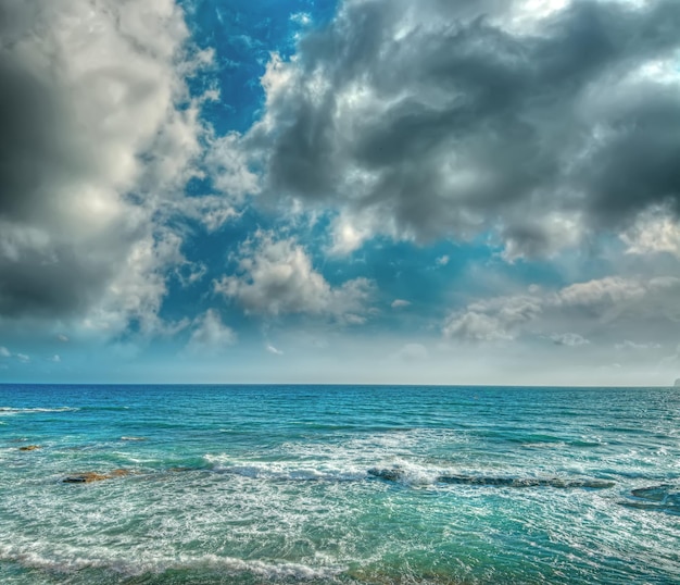 Golven en wolken in de kust van Alghero