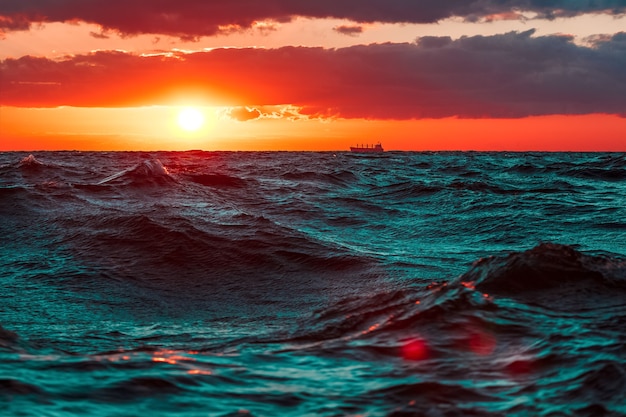 Golven in de oceaan tegen hete en romantische zonsondergang